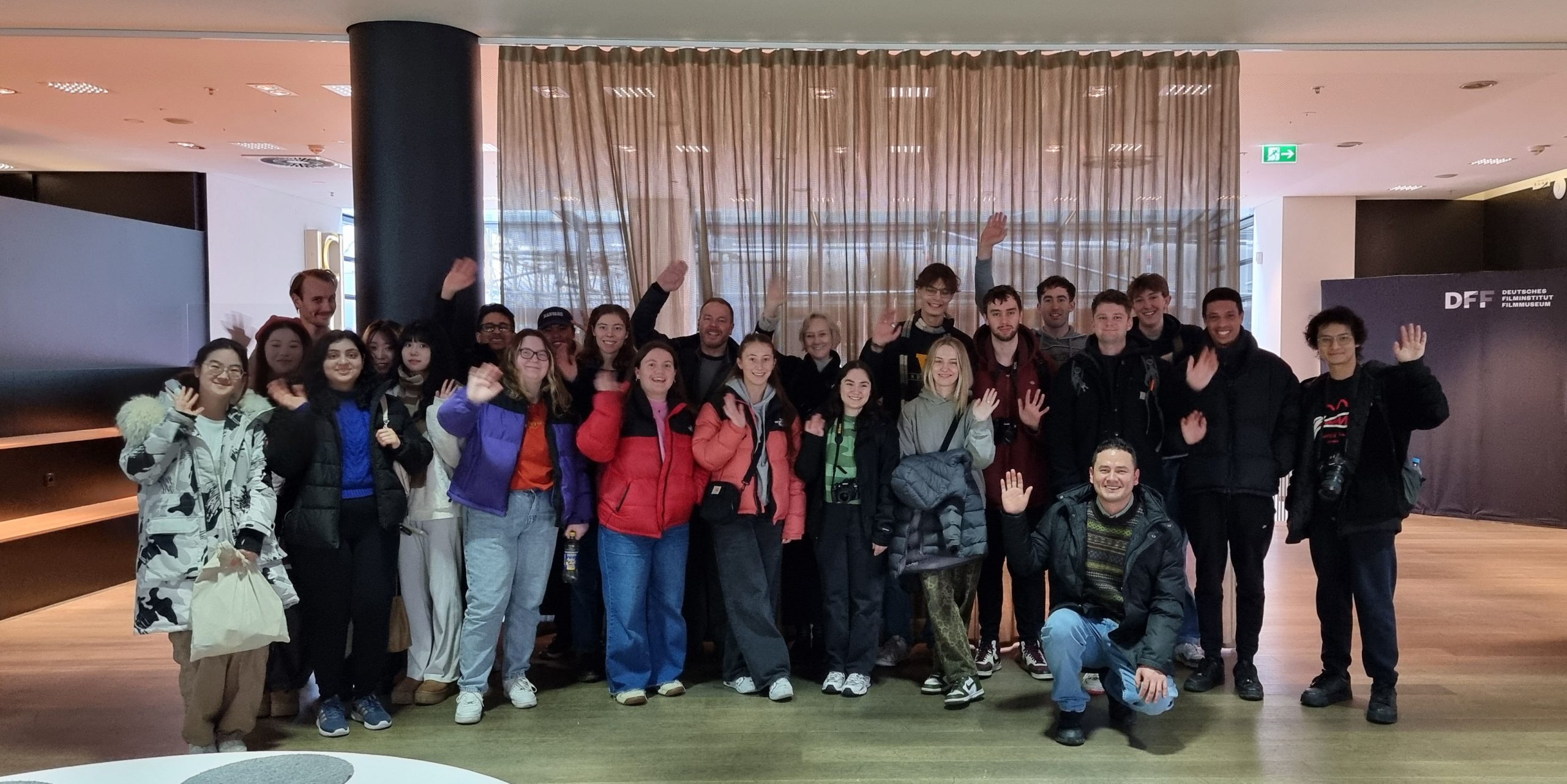 Group of students standing in a modern auditorium